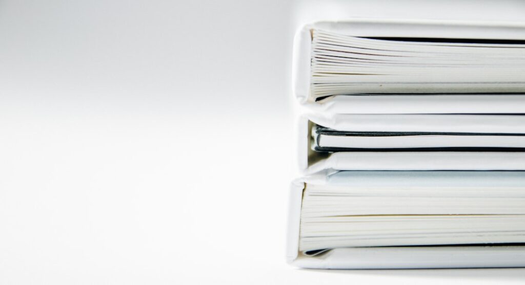 7 Must-Read Accounting Books for Small Business Owners A stack of thick folders on a white surface