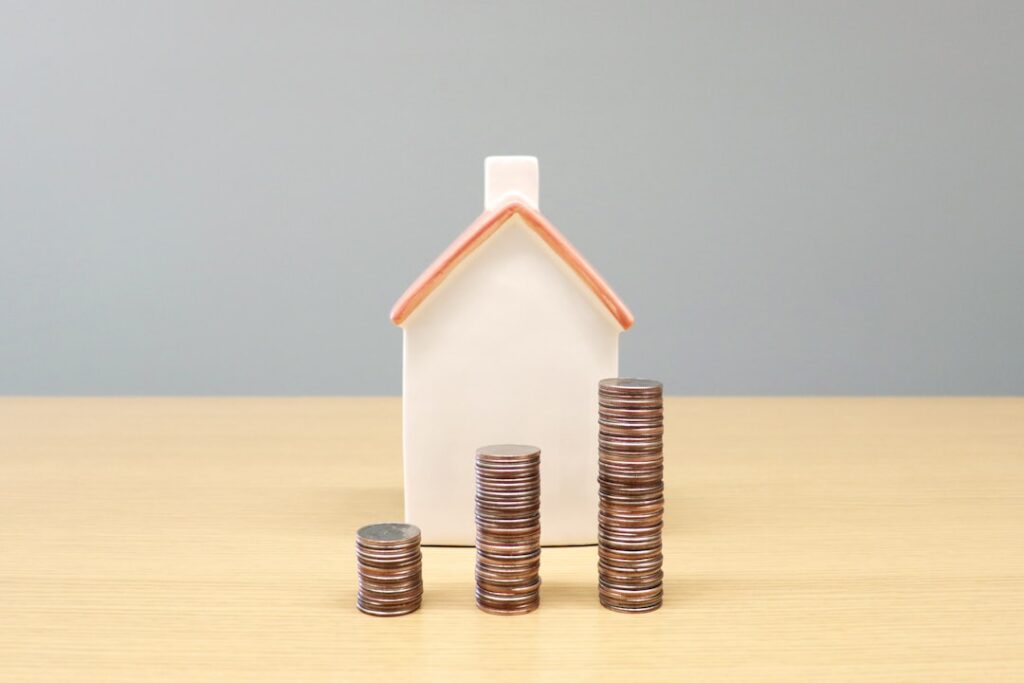 89 Housing Markets Face Price Declines: What's Driving It a house and stacks of coins on a table
