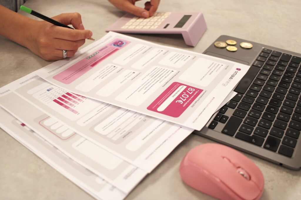 Best Payroll Software for US Businesses in 2024 Someone is doing taxes with a calculator and laptop.