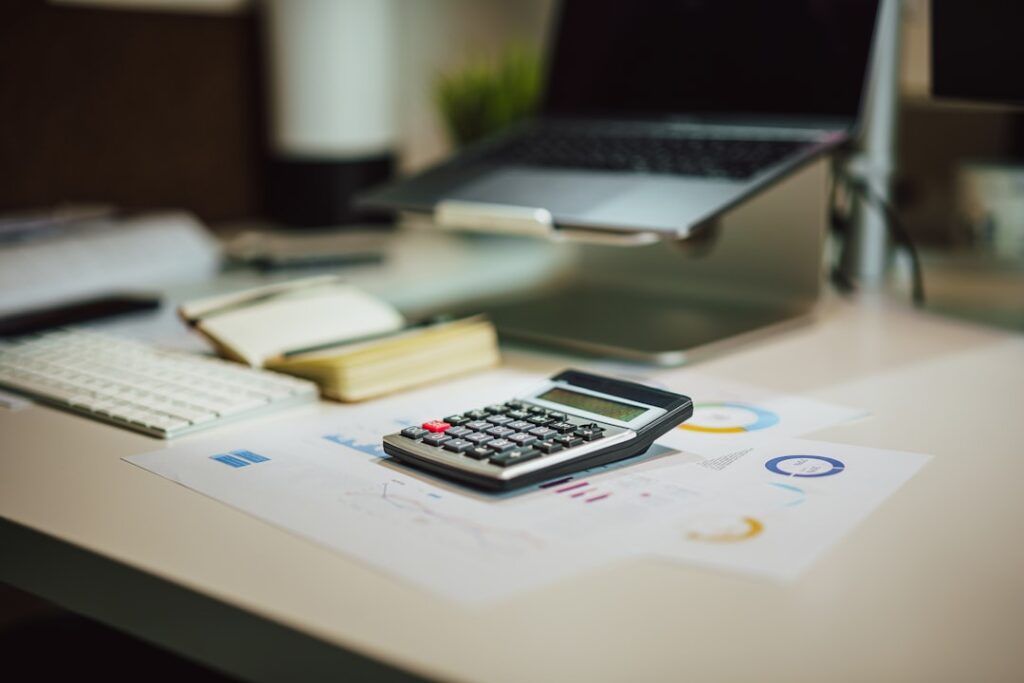 Best QuickBooks Alternatives for Small Business Accounting a calculator sitting on top of a table next to a laptop
