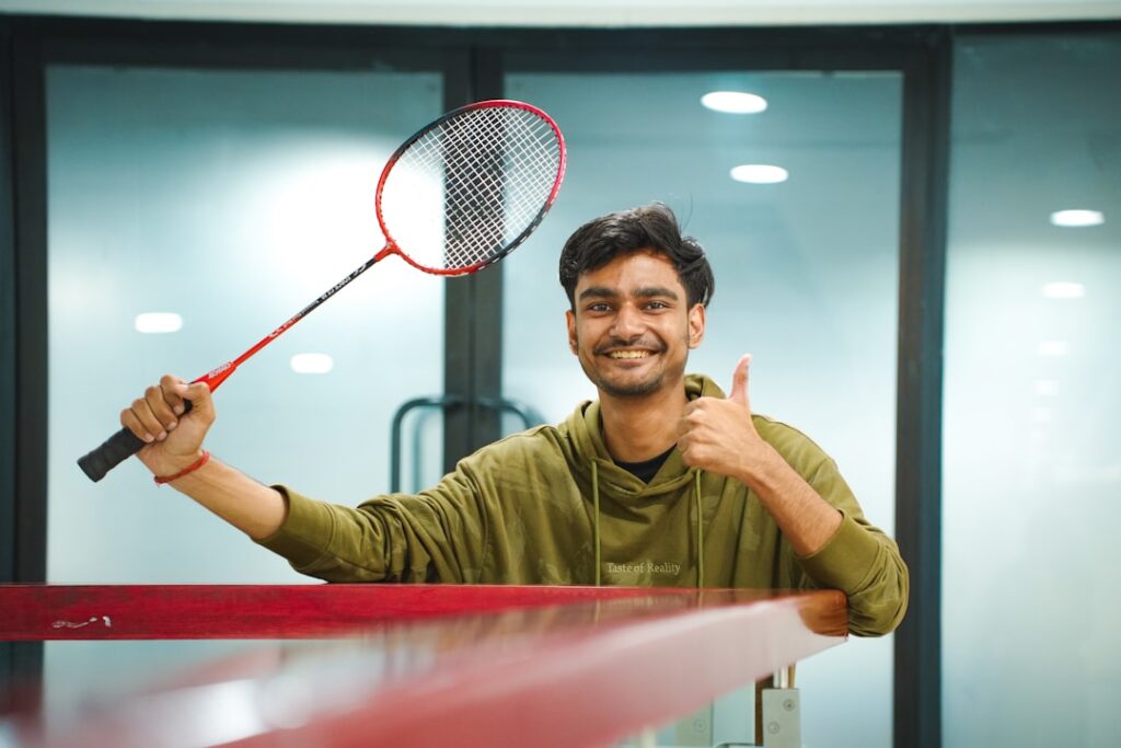 Body Language Expert Reveals $2B Sales Secret Man holding a badminton racket and giving a thumbs up