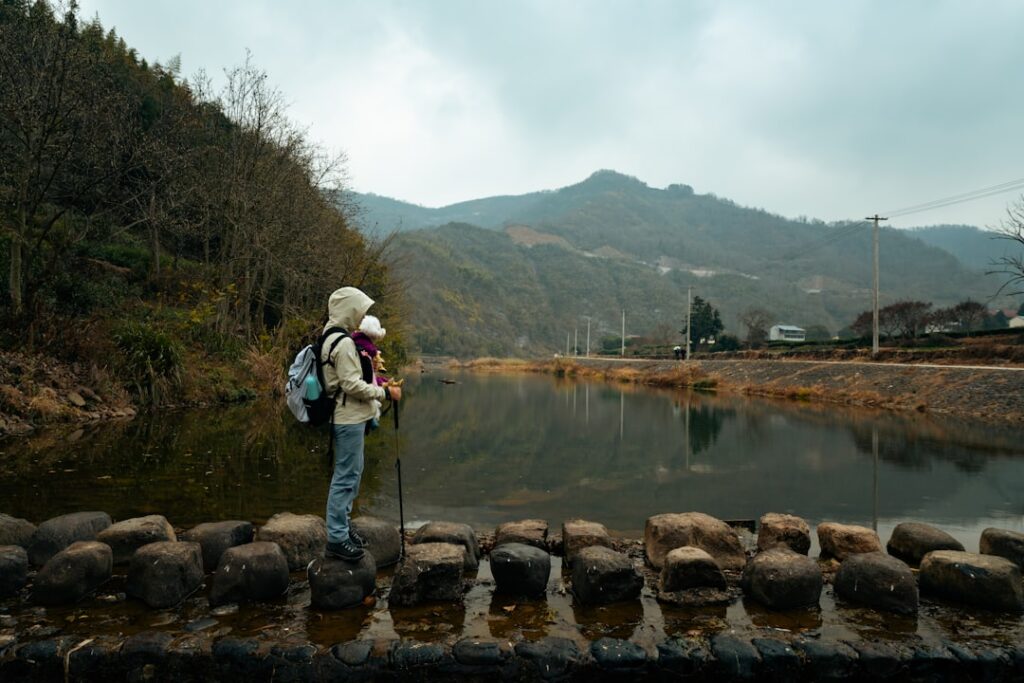 Dog Backpack Startup Hits $1M in Year One Hiker with backpack and poles by calm water.
