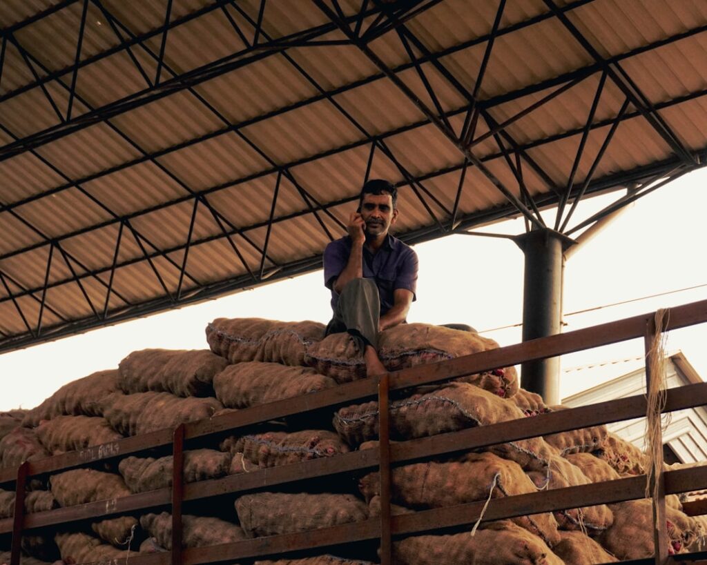 Arabica Coffee Prices Surge to Record After Trump Tariff Threat Ends a man sitting on top of a pile of bread