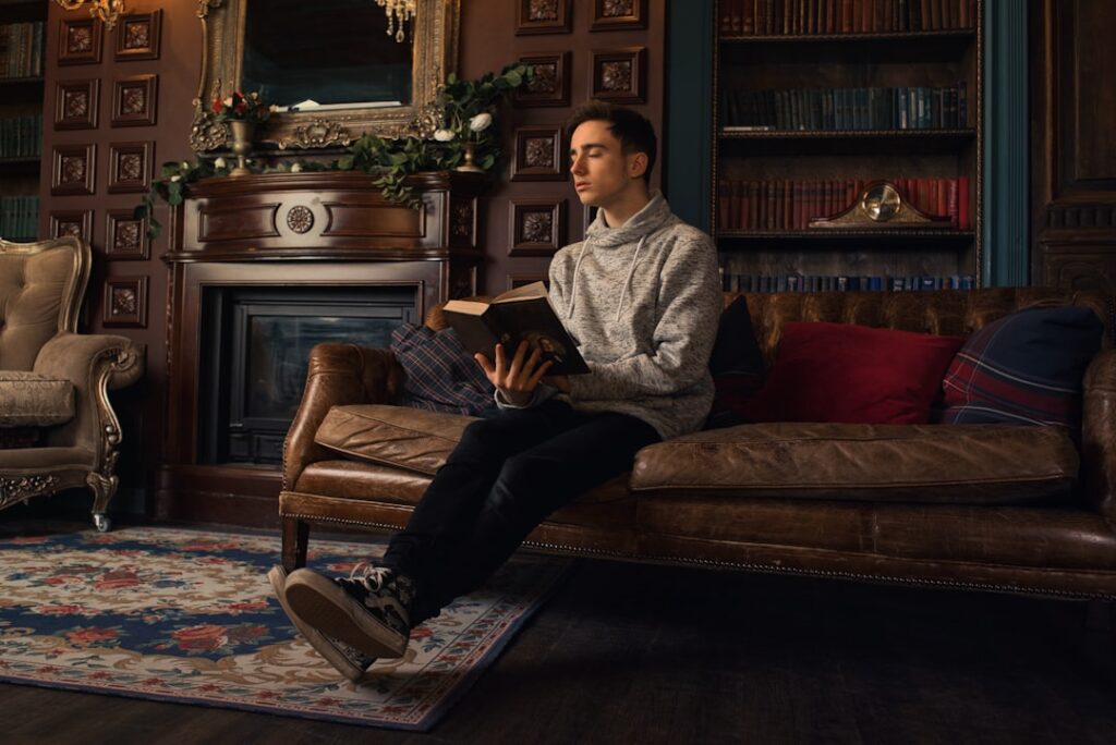 Reed Hastings Steps Down as Netflix Chairman a man sitting on a couch reading a book