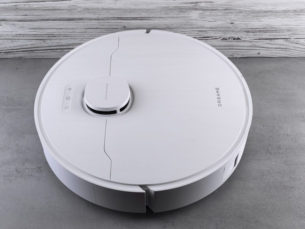 Pudu Robotics Expands into Europe with Dutch Partnership A white robot vacuum cleaner on a grey floor.
