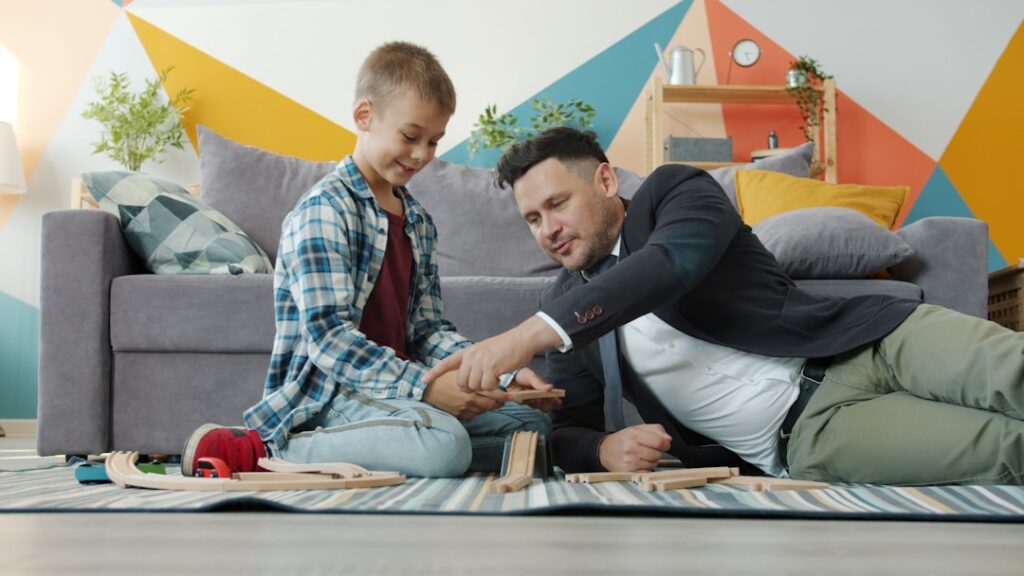 Young Men Living With Parents Hits 15-Year High Father and son playing with wooden blocks together.