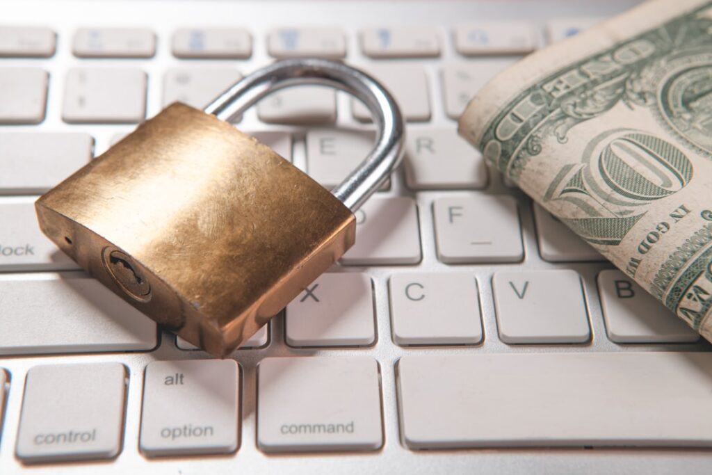 Fighting Back Against Sophisticated Scams: A Global Strategy A padlock and dollar bills rest on a computer keyboard.
