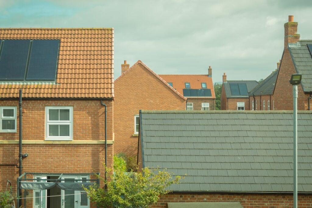 UK Energy Pricing Overhaul Targets Household Electricity Bills Houses with solar panels are shown in the image.