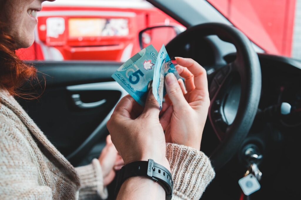 Car Finance Compensation: What Millions Need to Know woman riding on vehicle holding 5 banknote