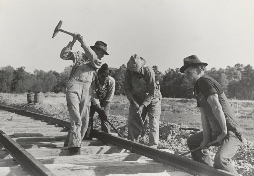 CPKC Inks Tentative Labor Deals With Rail Unions grayscale photography of four men holding mallet on train railway