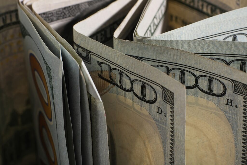 Master Cash Flow: 10 Essential A/R and A/P Strategies Close-up of folded hundred dollar bills.
