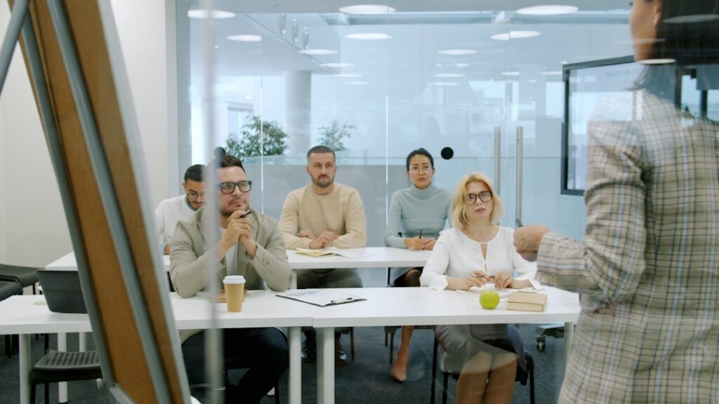 Employee Training Strategy: 7 Proven Development Methods Business people attending a presentation in a modern office.
