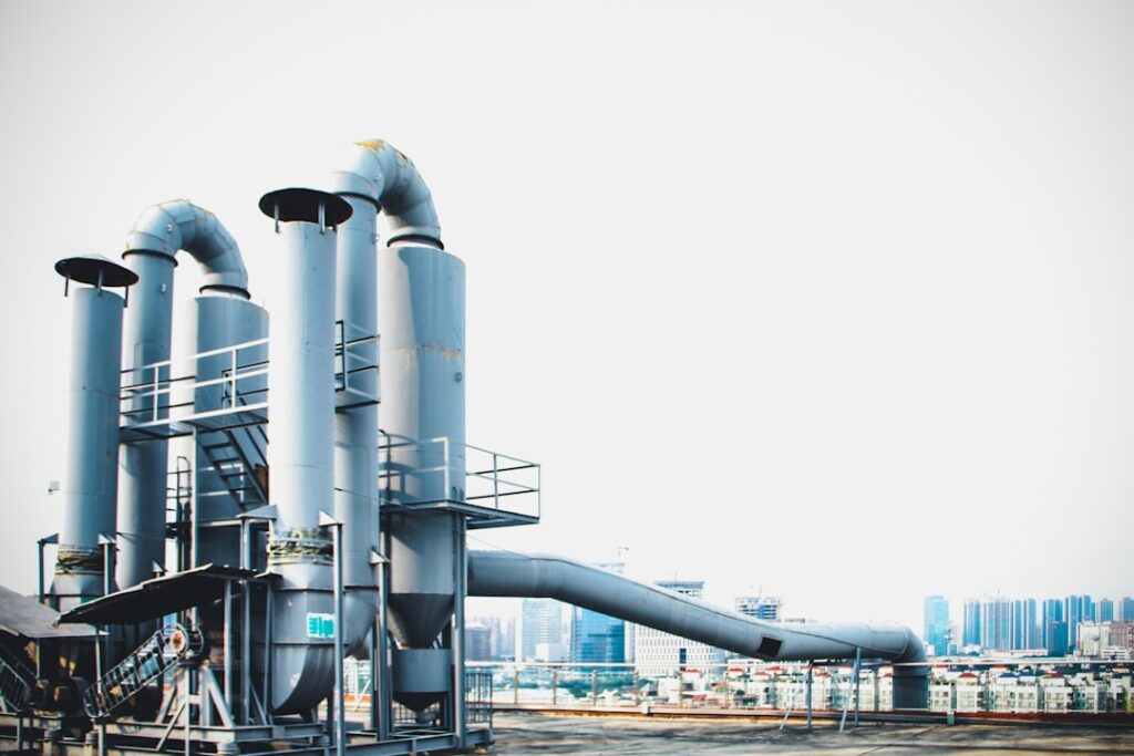 Microsoft Pauses Carbon Removal: What's Next for the Industry? a large metal pipe system in front of a city skyline