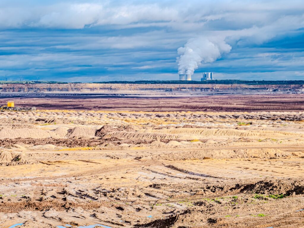 Coal Plant Retirements Hit 15-Year Low in 2025 Industrial power plant emitting smoke against cloudy sky.