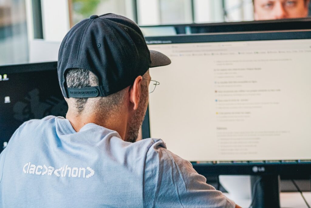 Digital Twins at Work: Productivity Tool or Legal Risk? Man wearing baseball cap working at computer