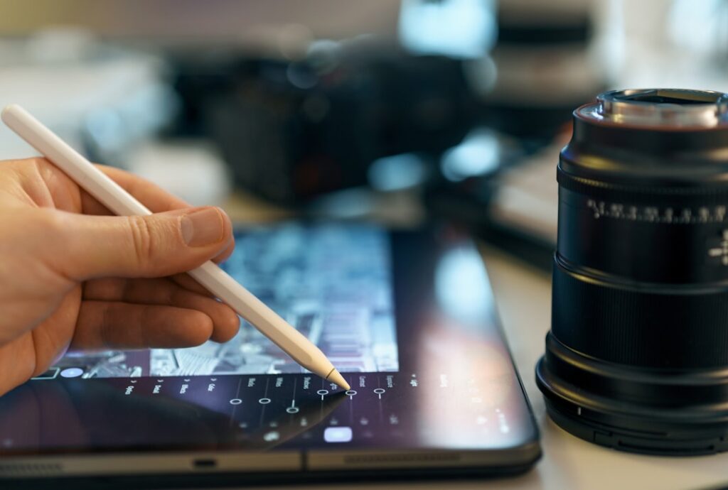 Google Photos Launches Quick Touch-Up Tools for Photo Editing Hand using stylus on tablet near camera lens