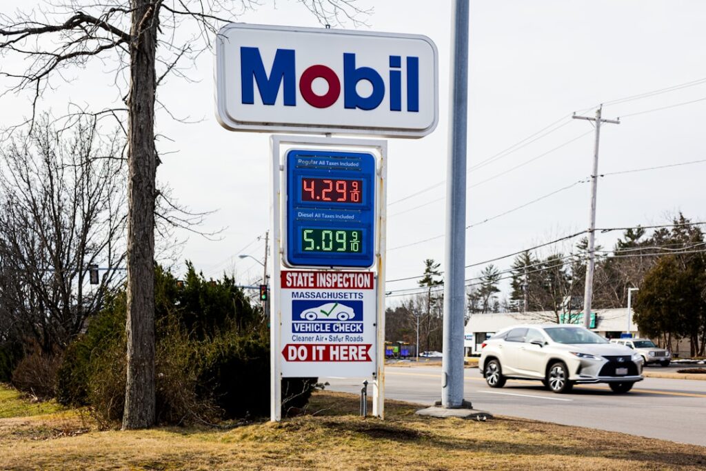 Iran Conflict Could Spike Prices for 8 Months, Official Warns a mobil gas station sign next to a road