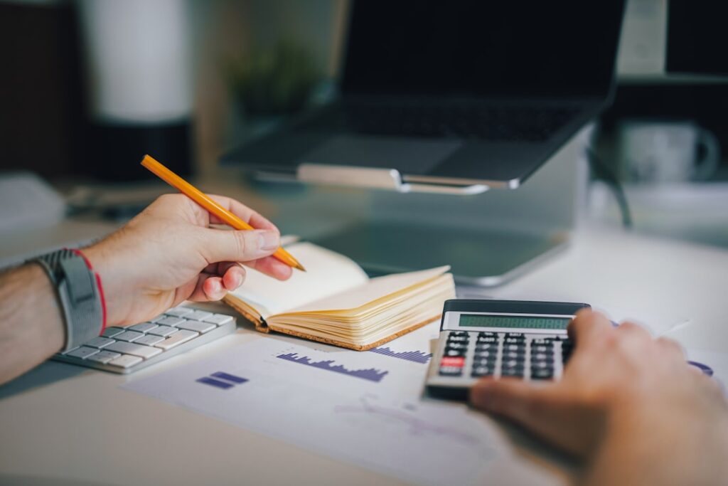 Master Bookkeeping Free: Top 5 Online Courses a person sitting at a desk with a calculator and a notebook