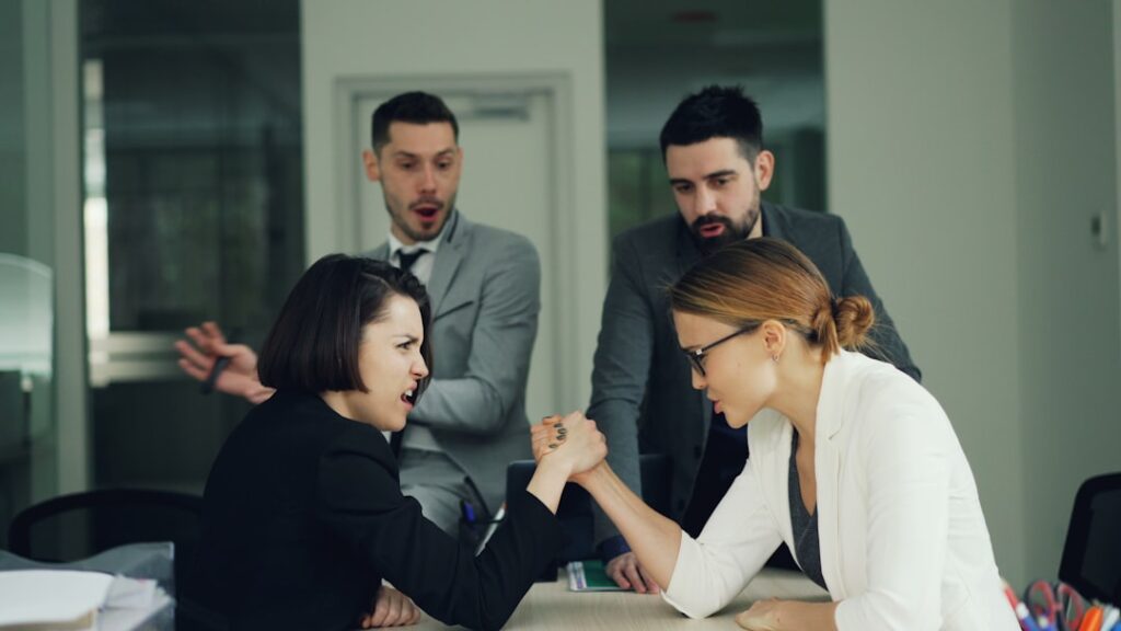 Master Conflict Resolution: Essential Strategies for Success Two women arm wrestling with men watching