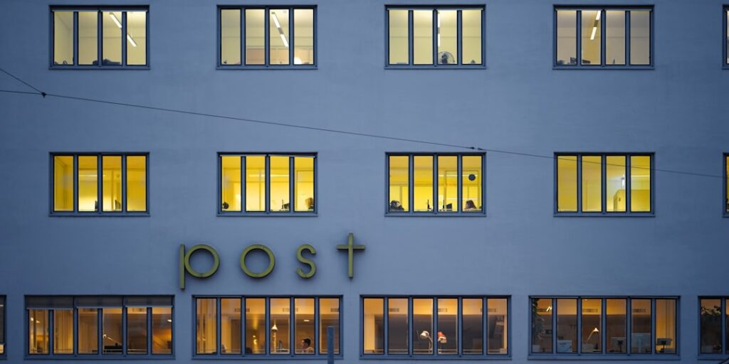 Master Cost Accounting: Essential Principles for Business Success Building with illuminated windows and "post" sign at dusk
