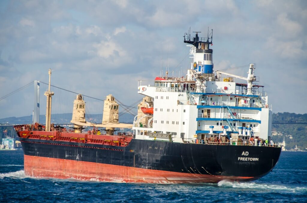 Oil Prices Drop as Iran Reopens Strait of Hormuz blue and white ship on sea under white clouds during daytime