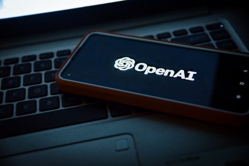 OpenAI Pivots to Enterprise as Anthropic Competition Intensifies a cell phone sitting on top of a laptop computer