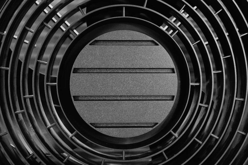 PHNIX Launches airMono Heat Pump for Urban Climate Control Close-up of a black circular grate with horizontal slats.