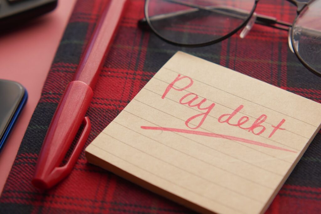 Private Student Loans: Why Parents Should Hesitate Before Cosigning a note that says pay debt next to a pen and glasses