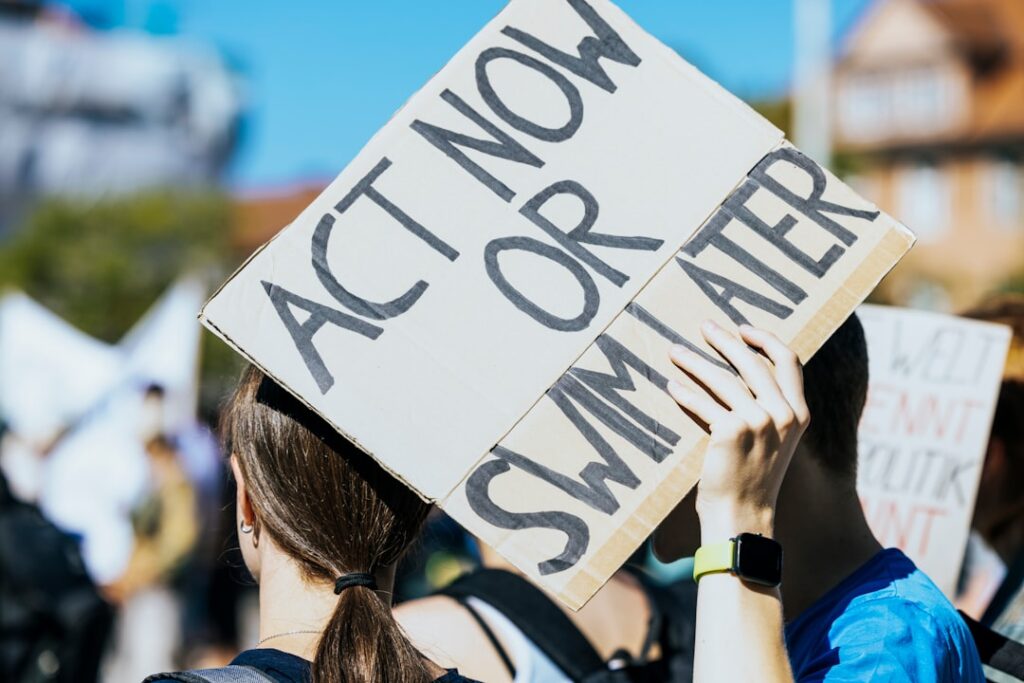 Rutgers Creates $1M Student Investment Fund for Real Trading a woman holding a sign that says act now or summer