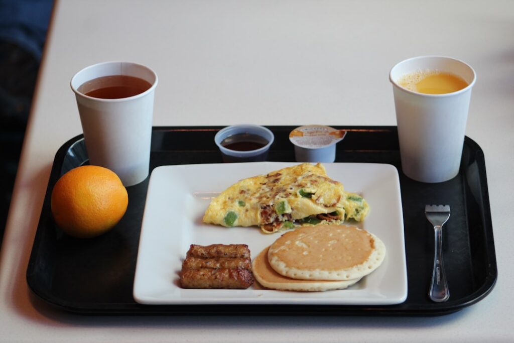School Breakfast Programs Face Funding Crisis egg omelet with sausage, pancake and coffee on tray