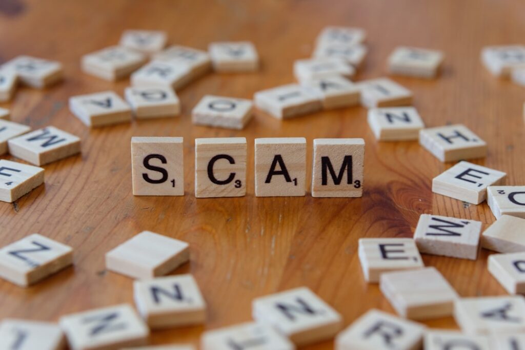 Social Media Scams Cost Americans $2.1B in 2025 Scam spelled with scrabbles on a wooden table