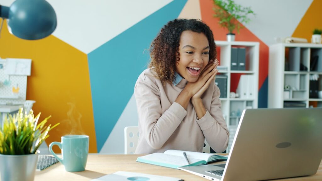 Stop Waiting to Be Ready—Start Now Instead Excited woman looking at laptop with steaming coffee.