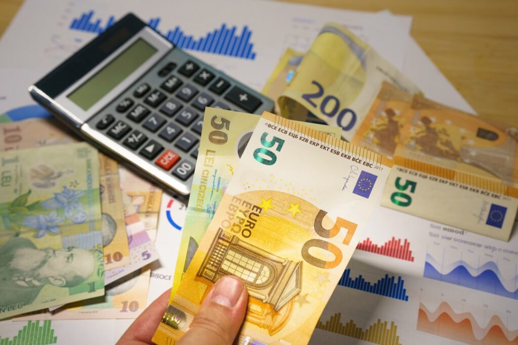 Taxable Business Income: Essential Guide for Owners A person holding a bunch of money next to a calculator
