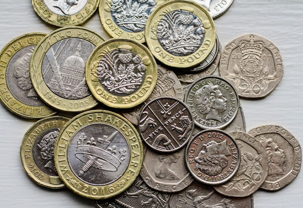 UK Borrowing Falls to 3-Year Low Amid Iran War Concerns a pile of british coins sitting on top of a table