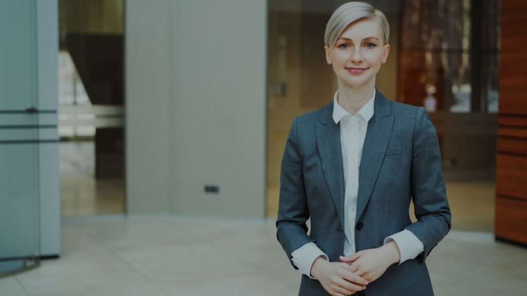 Why Top Leaders Embrace Humor Over Intensity A professional woman in a suit smiling confidently.