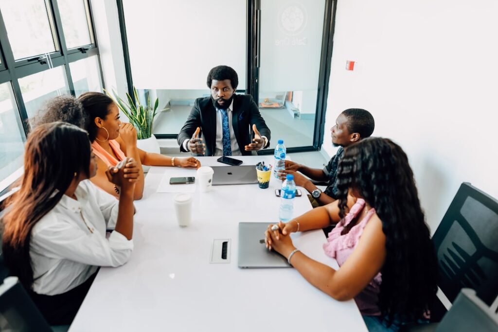 Why 'Why' Questions Backfire in Corporate Settings A group of people sitting around a white table