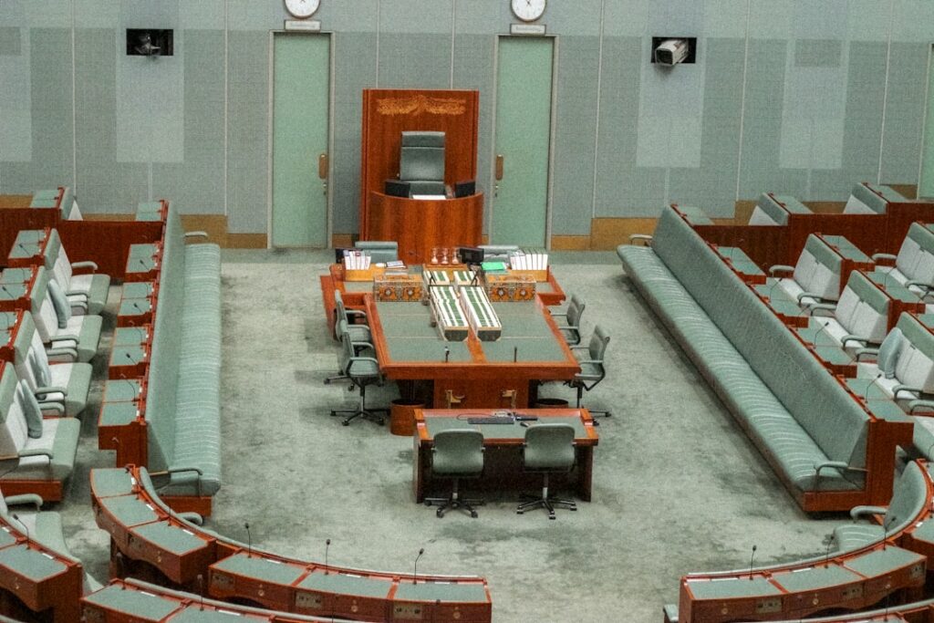 Airbnb Co-Founder Taps Design Legend for Federal Role An empty parliamentary chamber with seating and a central table