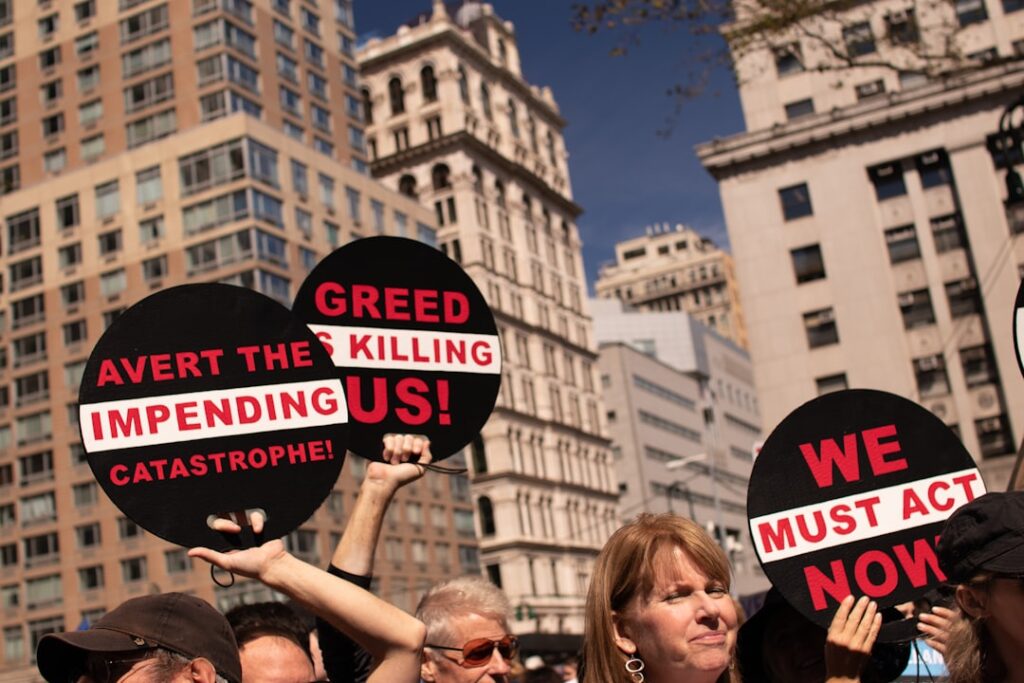 Bezos Met Gala Attendance Sparks Wealth Inequality Outcry people raising signage near buildings