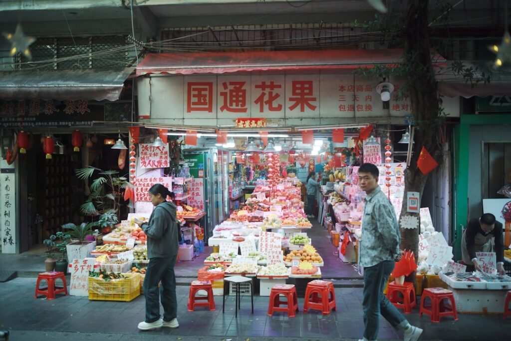 Canton Fair Phase 3 Launches 9 New Product Zones People walk past a busy fruit and flower market stall.