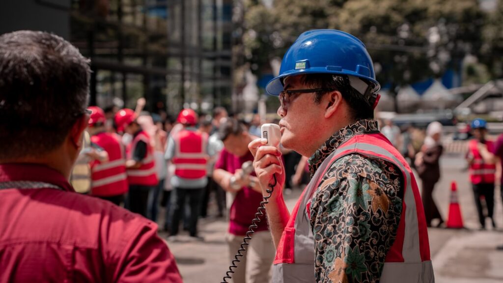 Conrad Lynch Appointed EHS Director at Richard Purpose Builders Man in hard hat speaks into a megaphone to workers.