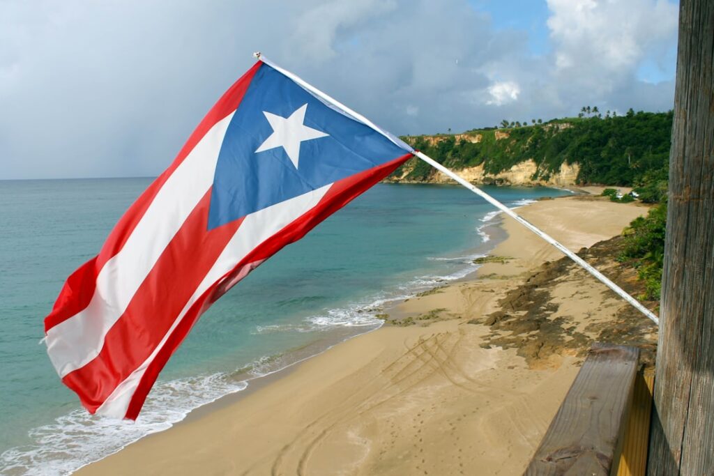 Contrarian Investing: Why Puerto Rico's Crisis Created Opportunity red and white flag on beach shore during daytime