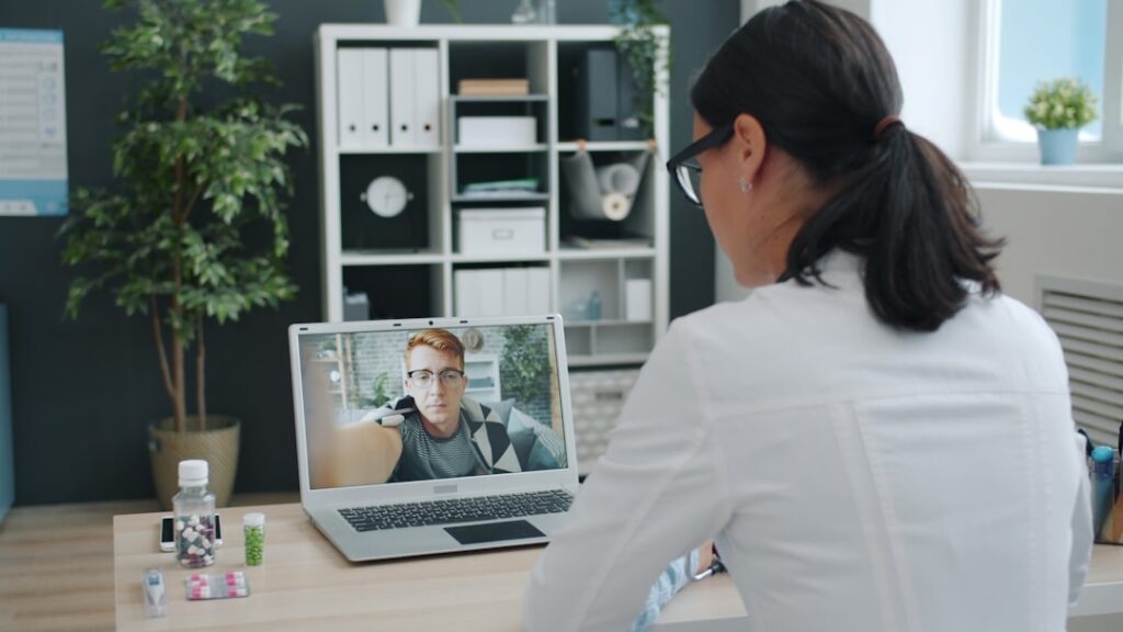 Doctor Turns Health Crisis Into $100M Empire Doctor consulting patient via video call on laptop.