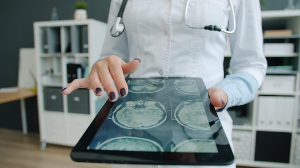 Harvard Study: AI Outperforms Doctors in ER Diagnoses Doctor shows brain scan on tablet in office