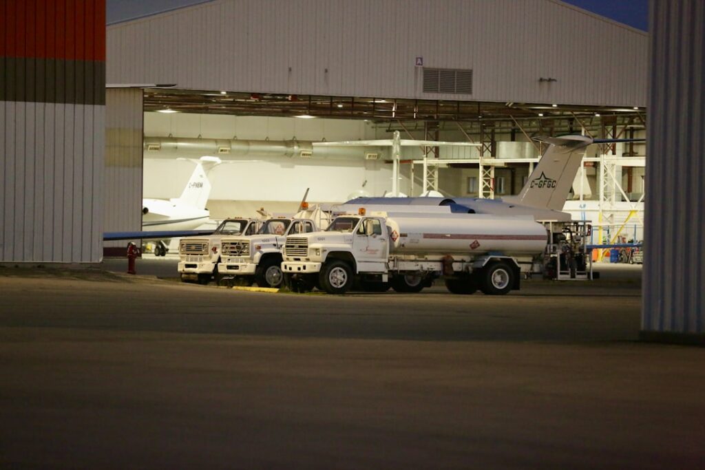 Jet Fuel Shortage Threatens Summer Travel Plans two trucks parked in front of a hangar