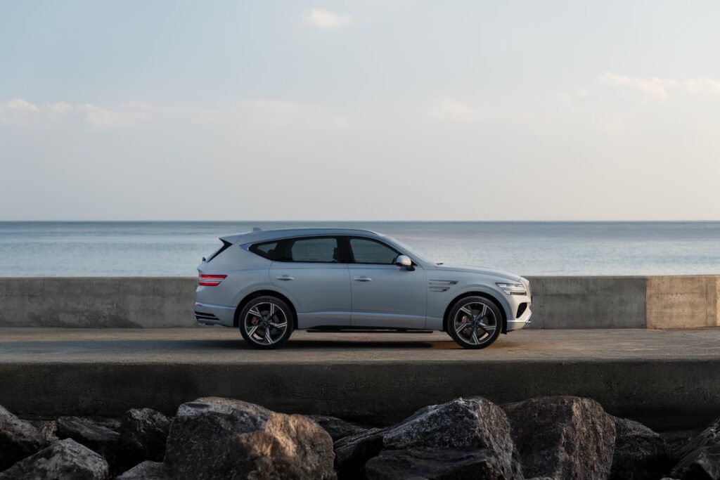 Matthew & Kaylyn Noonan: Building Richwife Empire A light gray suv parked by the ocean.