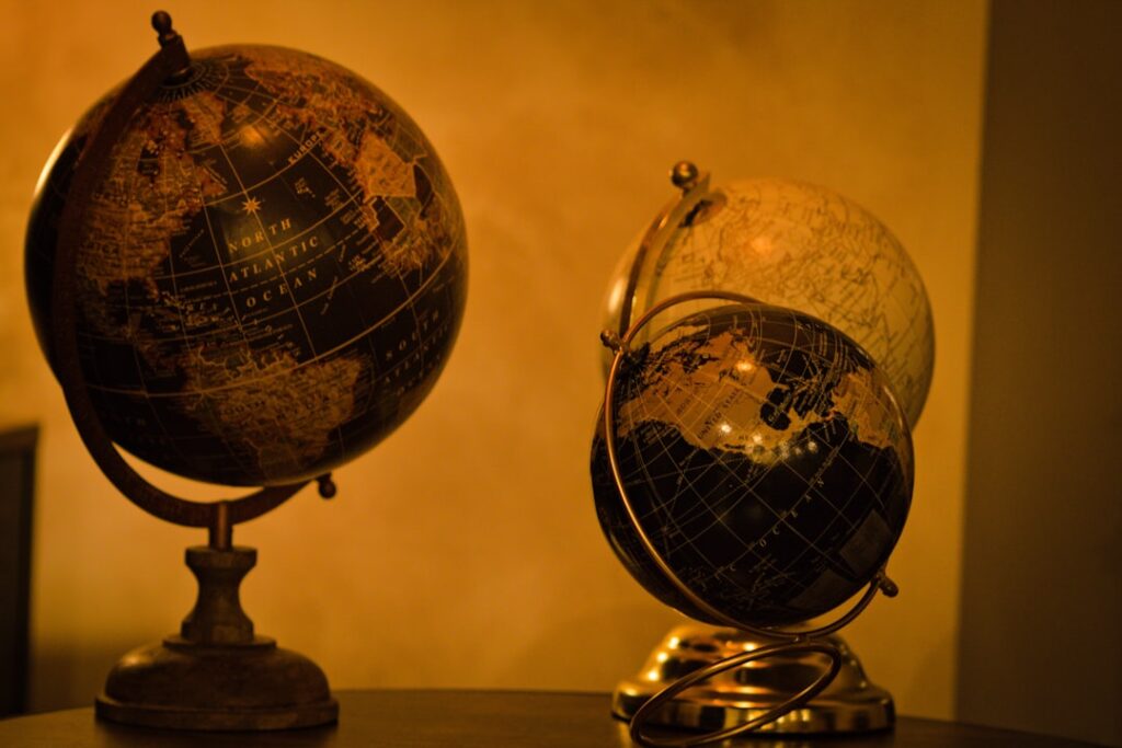 NEI Global Relocation Dominates 2026 Mobility Survey Three antique globes on a wooden surface