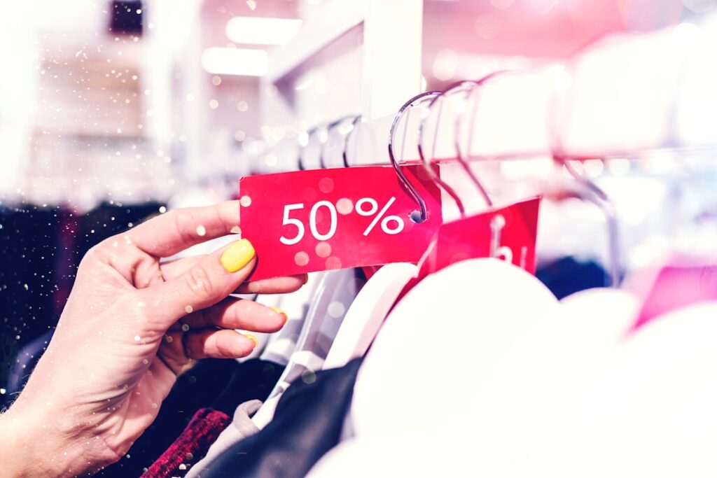 Next Hikes Prices Up to 8% Globally Amid Iran Tensions person holding red and white love print gift wrapper