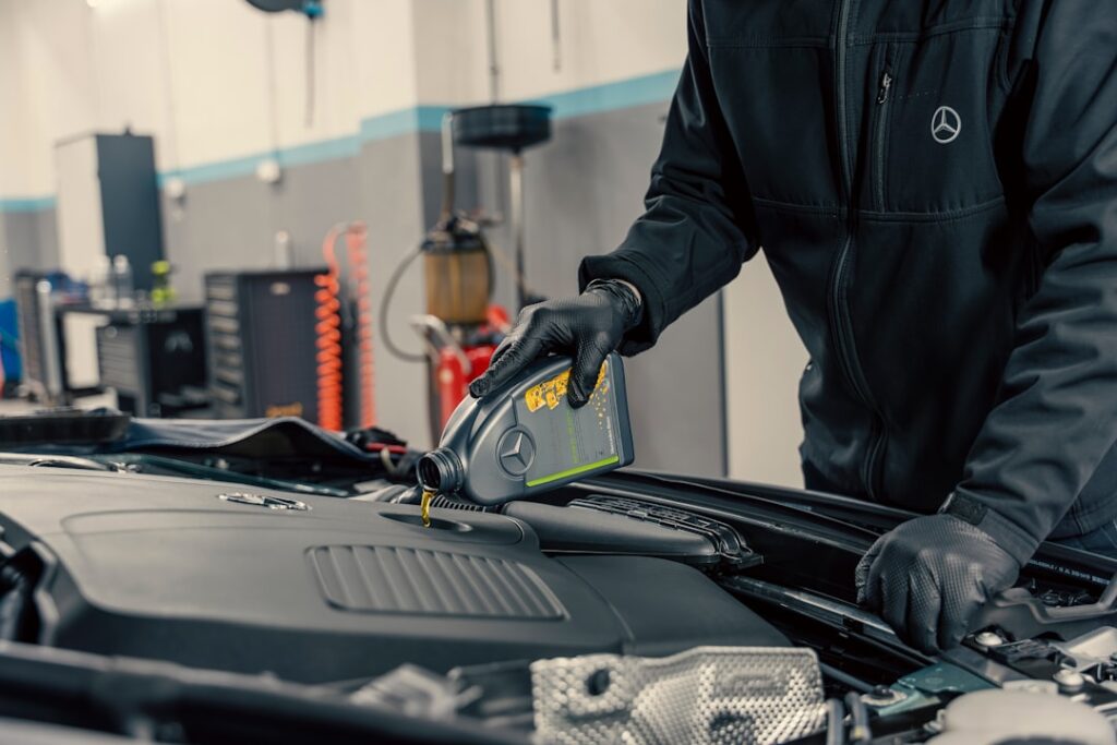 Oil Change Intervals: Expert Guide to Engine Maintenance Mechanic pouring oil into car engine