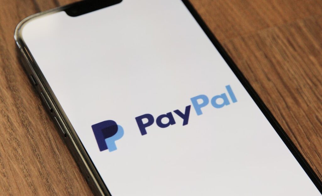 PayPal's AI Pivot: $1.5B Savings Through Tech Overhaul a phone with a pay pay logo on it
