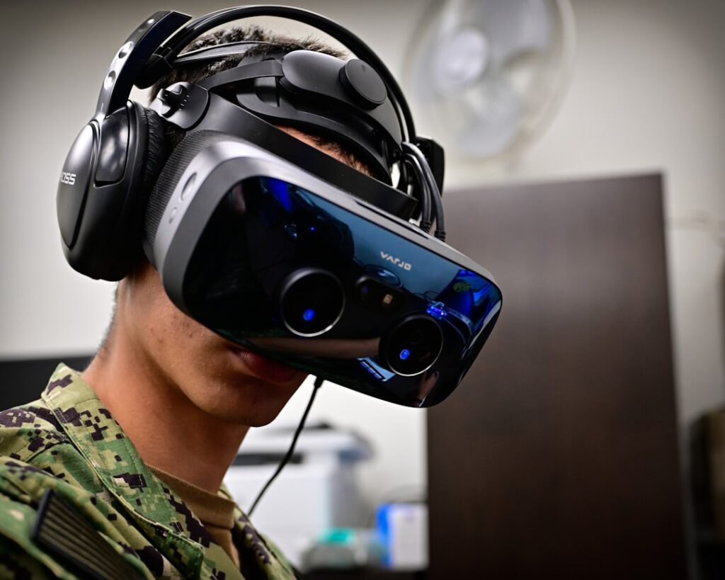 Pentagon Embraces AI-First Military Strategy With Tech Deals Person wearing a virtual reality headset and headphones.